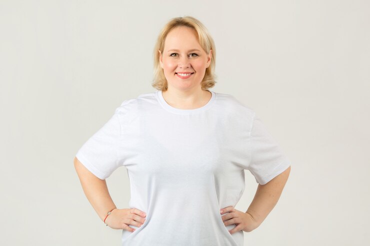 Hermosa joven regordeta en una camiseta blanca sobre un fondo blanco.