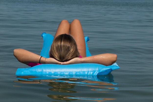 Hermosa joven relajándose en un colchón inflable