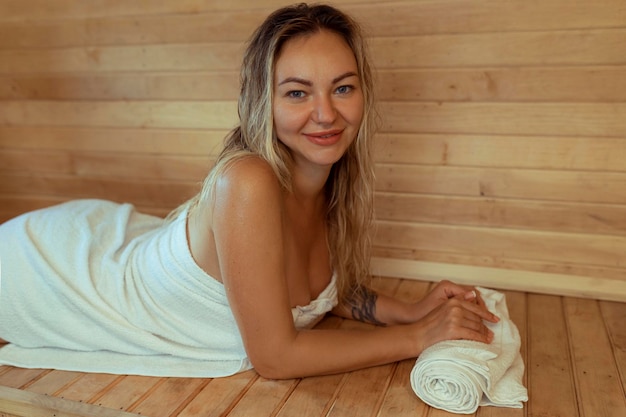 Hermosa joven relajándose en la sauna finlandesa