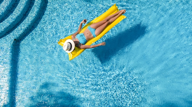 Hermosa joven relajante en la piscina