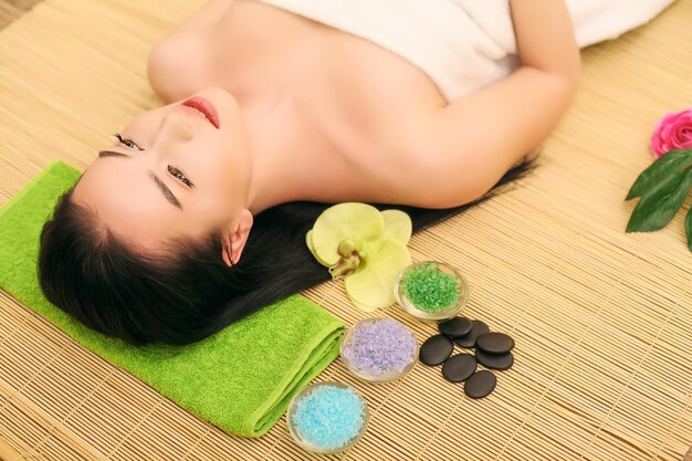 Hermosa joven relajante en el salón de spa.