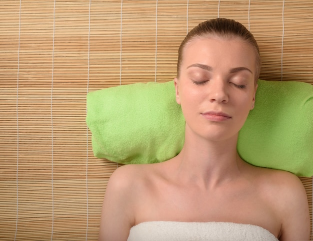 Hermosa joven relajante en el salón de spa