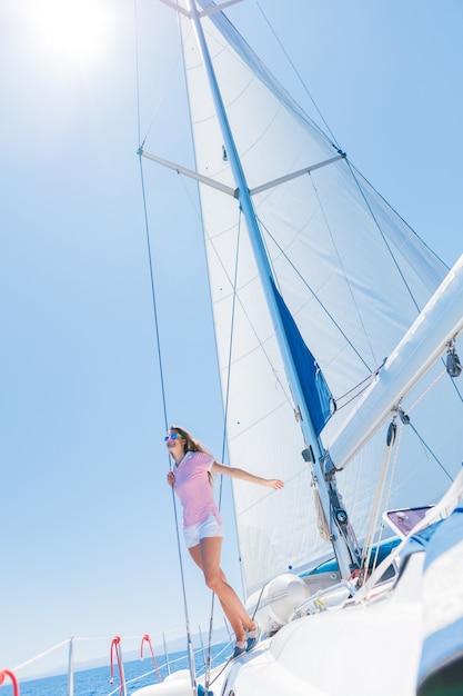 Hermosa joven relajante en yate en Grecia