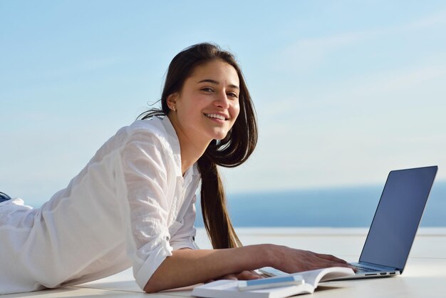 hermosa joven relajarse y trabajar en una computadora portátil moderna oficina en casa