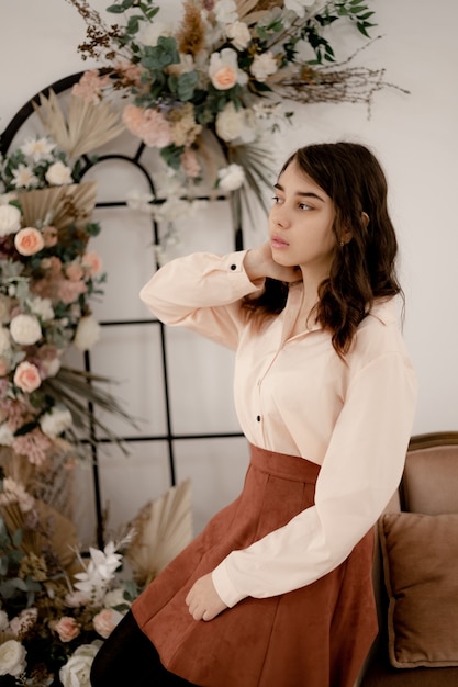 Hermosa joven rizada en el interior de una casa floral