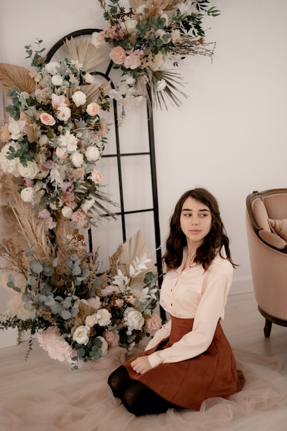 Hermosa joven rizada en el interior de una casa floral