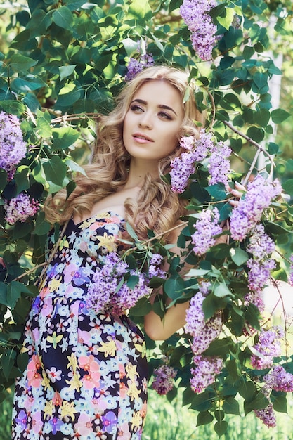 Hermosa joven rodeada de flores lilas