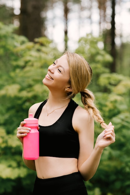 Hermosa joven en ropa deportiva agua potable