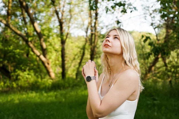 Hermosa joven rubia en el bosque La chica disfruta de la naturaleza