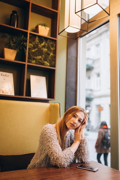 Hermosa joven rubia en un café