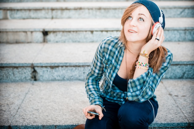 hermosa joven rubia hipster mujer escuchando música