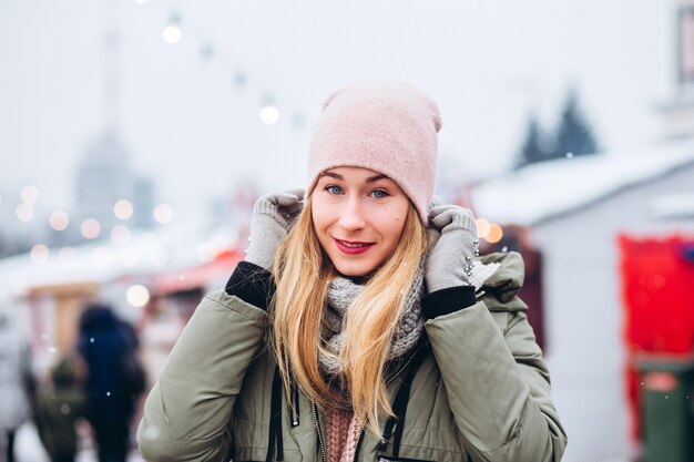 Hermosa joven rubia en el mercado de Navidad