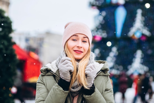 Hermosa joven rubia en el mercado de Navidad