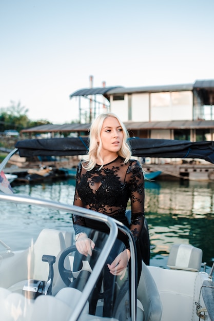 Hermosa joven rubia, montando un bote en el agua.