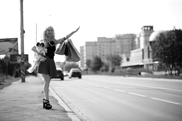 Hermosa joven rubia en un paseo con perrito