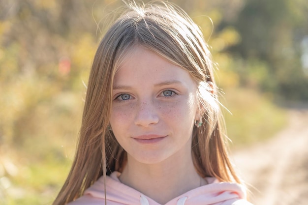 Hermosa joven rubia con pecas al aire libre en el fondo de la naturaleza en otoño retrato de cerca