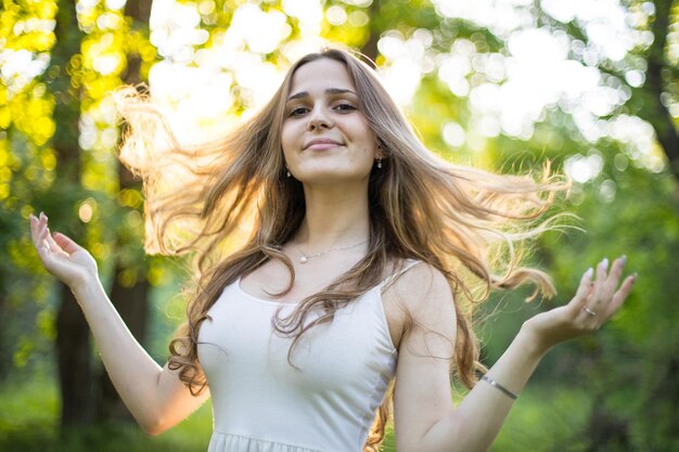 Foto una hermosa joven rusa vestida con un vestido blanco camina por el bosque entre los robles