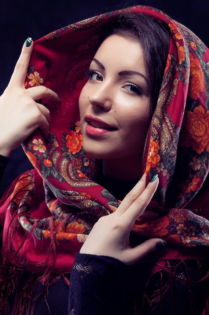 Foto hermosa joven rusa vistiendo mantón ruso tradicional rojo sobre fondo negro