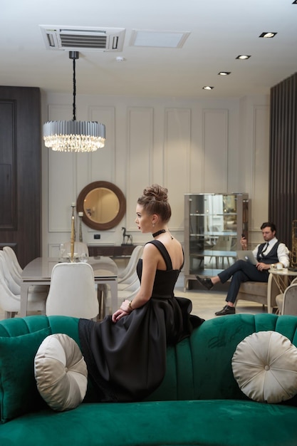 Hermosa joven sentada en un sofá verde en una habitación luminosa