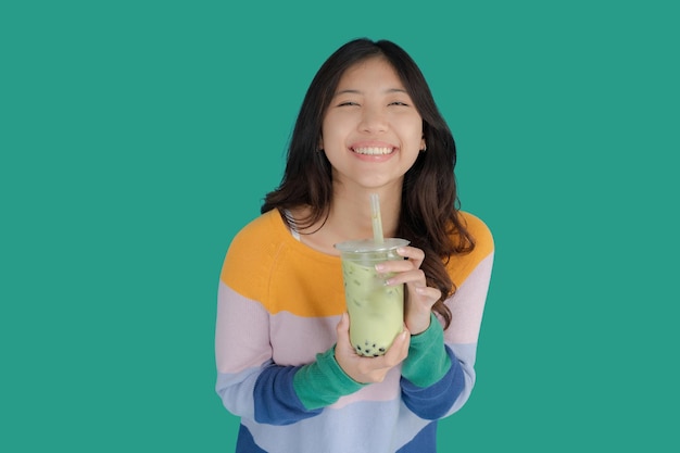 Hermosa joven sonriendo alegremente mientras sostiene té de burbujas en la mano