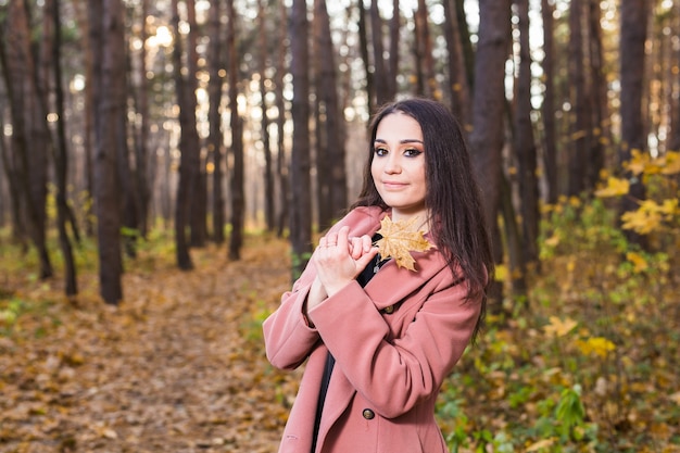 Hermosa joven sonriendo en el parque otoño