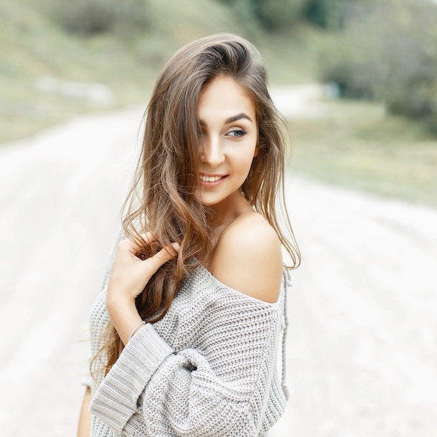 Hermosa joven sonriendo con peinado rizado en suéter vintage