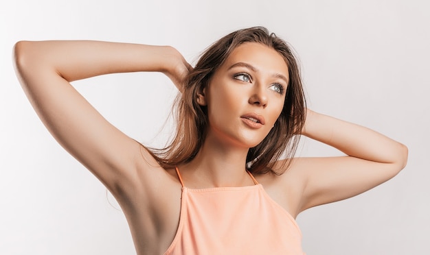 Foto hermosa joven sonriendo y posando mirando a la cámara sobre un fondo blanco aislado. mujer morena positiva. mirada amable. rostro de belleza.