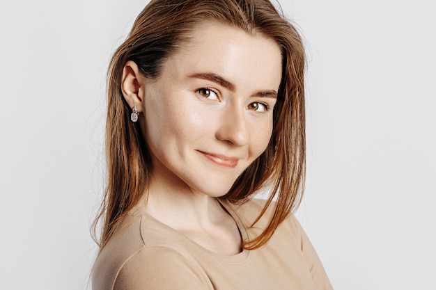 Hermosa joven sonriendo sobre un blanco aislado