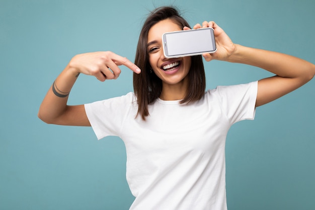 Hermosa joven sonriente apuesto vistiendo ropa casual elegante que se encuentran aisladas