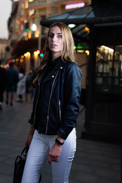 Hermosa joven sonriente en la ciudad de noche