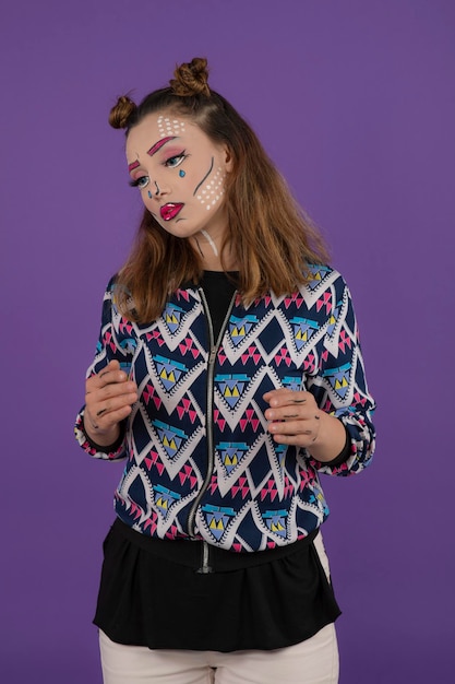 Hermosa joven con soporte de maquillaje de fantasía sobre fondo púrpura. foto de alta calidad