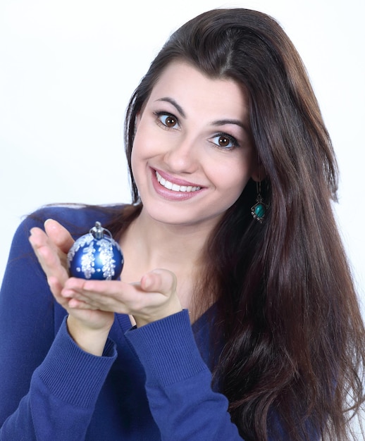 Hermosa joven sosteniendo una bola de navidad azul