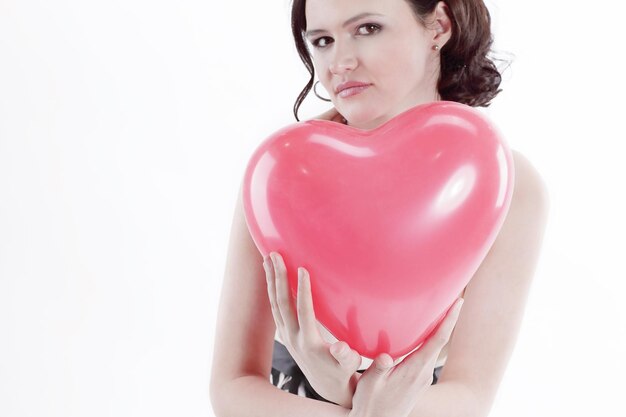 Hermosa joven sosteniendo corazón globo rojo