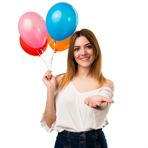 Hermosa joven sosteniendo un globo y sosteniendo algo