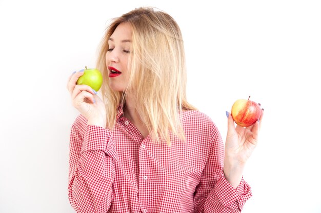Hermosa joven sosteniendo manzanas frescas sobre fondo blanco.
