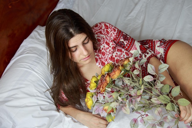 Hermosa joven sosteniendo un ramo de flores secas