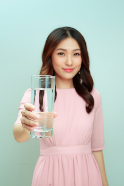 Hermosa joven sostiene un vaso con agua