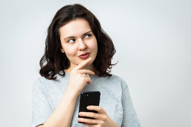 Foto una hermosa joven con el teléfono mirando a un lado