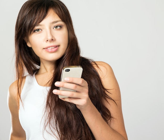 Hermosa joven con un teléfono en sus manos