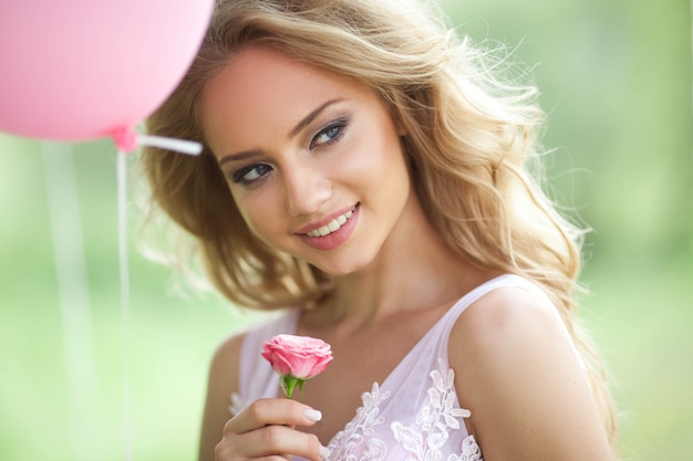 hermosa joven con tierna flor rosa en las manos