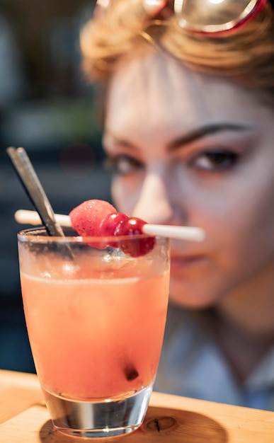 Hermosa joven tomando una copa en el bar