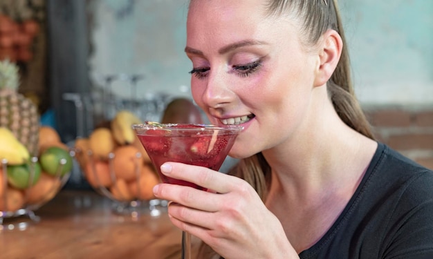 Hermosa joven tomando una copa en la discoteca