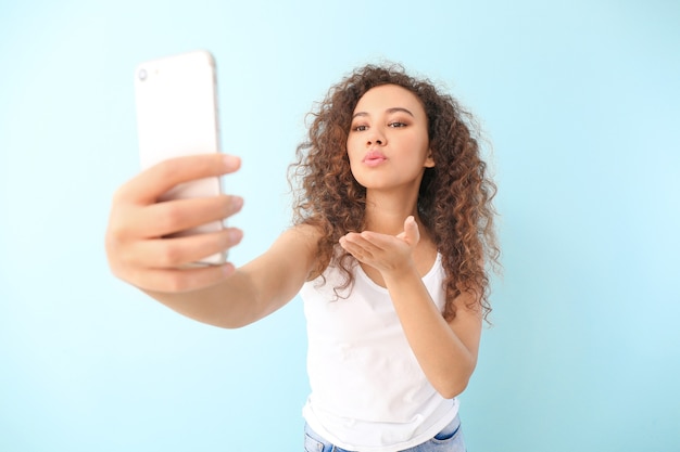 Hermosa joven tomando selfie en color