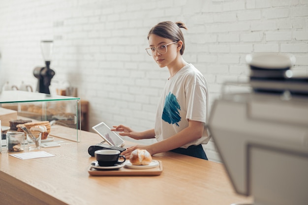 Hermosa joven trabajando en la cafetería. | Foto Premium