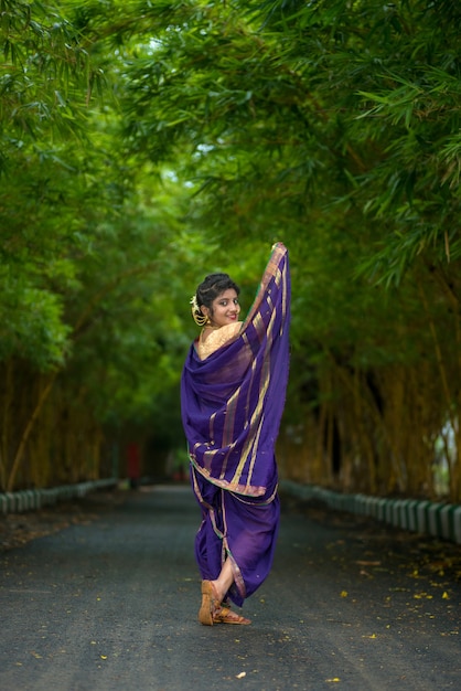 Foto hermosa joven tradicional india en sari posando al aire libre