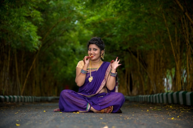 Hermosa joven tradicional india en sari posando al aire libre