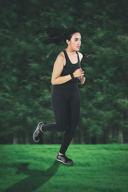 Hermosa joven trotando en el parque