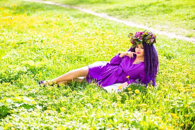 Hermosa joven tumbado en el campo de flores