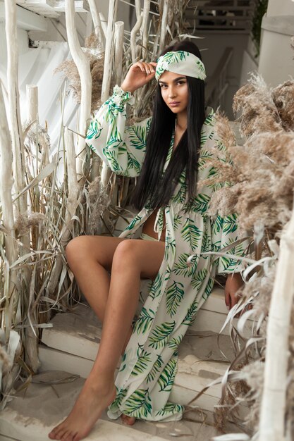 Una hermosa joven en una túnica de playa de moda