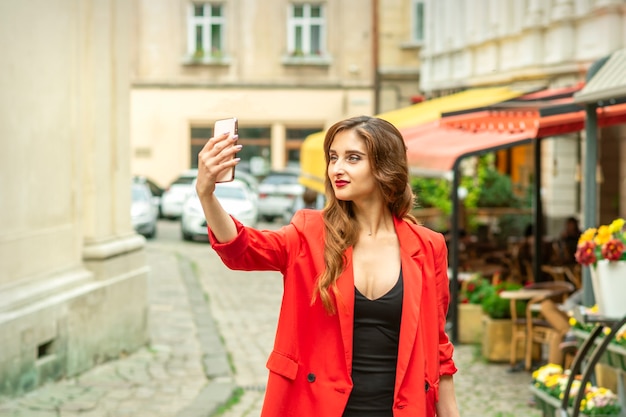 Hermosa joven turista caucásica toma un selfie en una ciudad europea